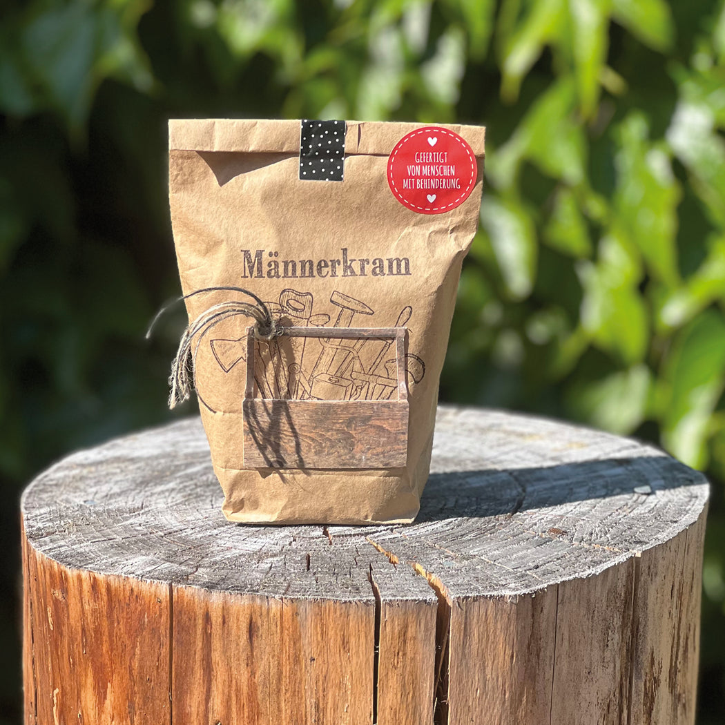 Männerkramtüte auf Baumstamm